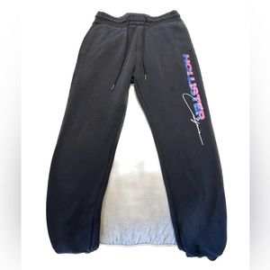 Hollister black joggers with pink/blue side writing.
